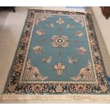 A Chinese inspired rug, decorated with floral designs,