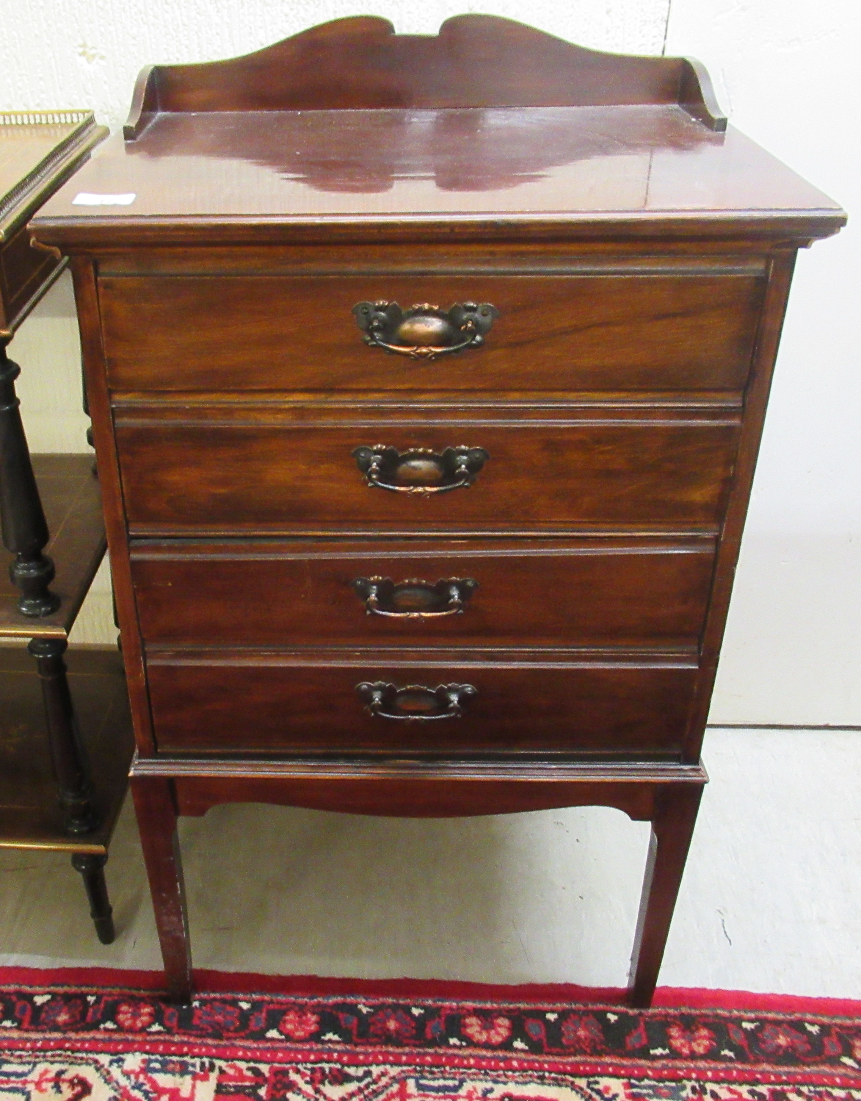 An Edwardian mahogany music cabinet with four fall front drawers, raised on square,