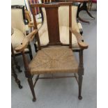 An early 20thC Arts & Crafts oak framed hall chair with a woven rush seat,