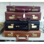 Four black and brown hide briefcases (combination codes unknown) TOS9