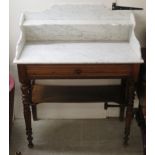An early 20thC walnut washstand with a mottled grey marble top and shelved superstructure,