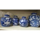 Four late 19thC early 20thC Chinese blue and white glazed porcelain prunus pattern ginger jars and