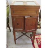 An early 20thC oak smoker's cabinet, the pair of lockable, glazed,