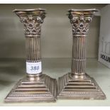 A pair of late Victorian loaded silver candlesticks, fashioned as a Corinthian capital,