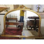 A modern round arched overmantel mirror,