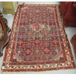 A Persian rug with a central gul on a red ground 78'' x 49'' CA