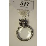 A silver magnifying glass pendant, incorporating a fox's head,