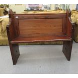 A late 19thC pitch pine pew with a panelled back,