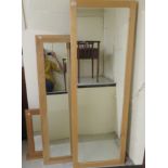 A light stained beech framed bevelled dressing mirror 65'' x 22''; another,