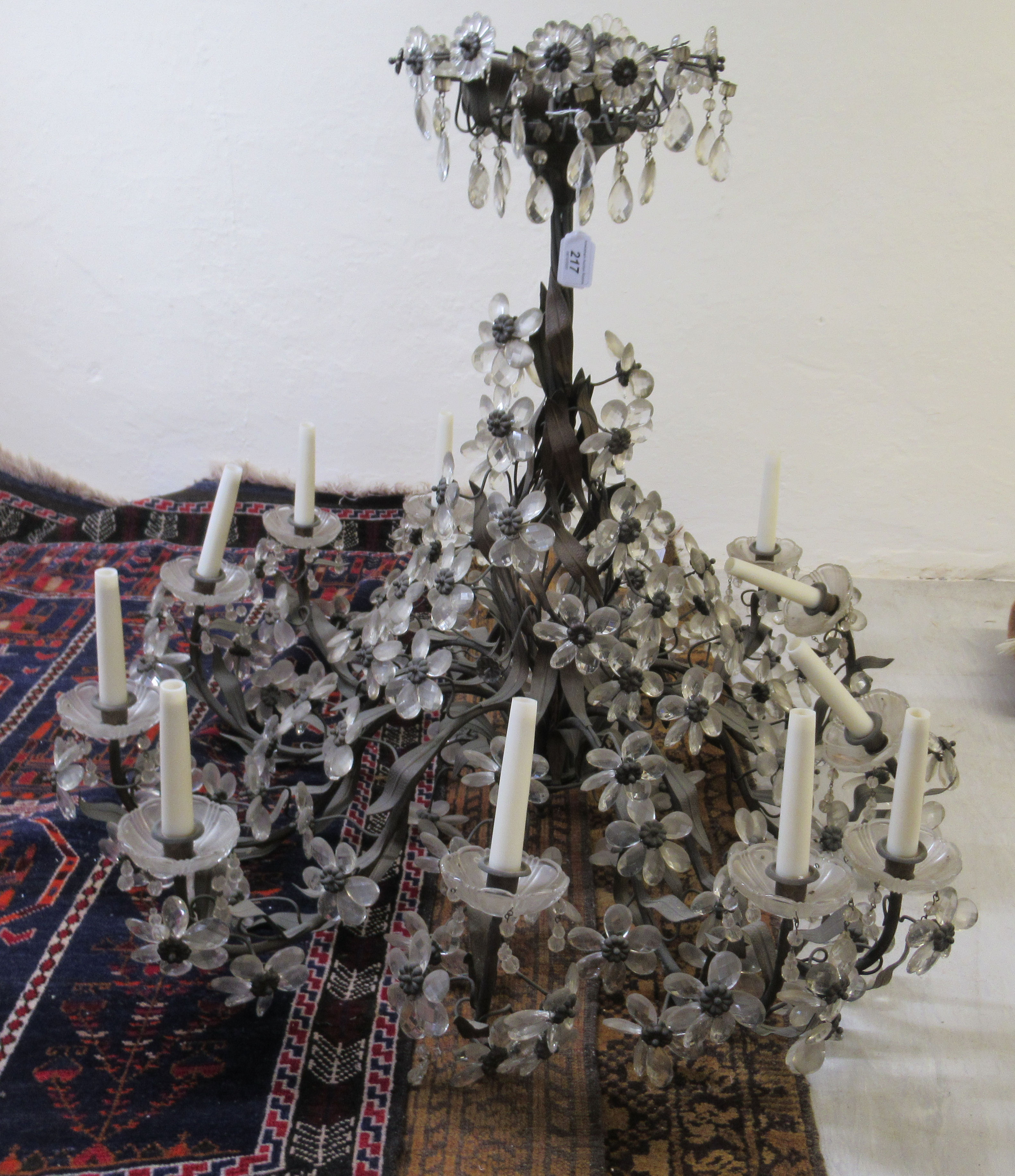 A chandelier, comprising twelve scrolled, candle style fittings,