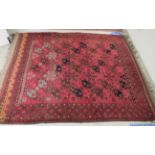 A Persian carpet, decorated with repeating octagonal guls and stylised designs,