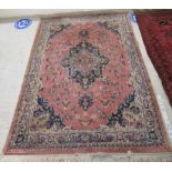 A Persian rug, decorated with stylised flora and other designs,