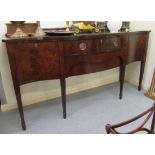 A Regency style figured and crossbanded mahogany, serpentine front sideboard,