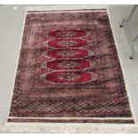 An Isfahan part silk woollen rug with a central bank of five octagonal guls,