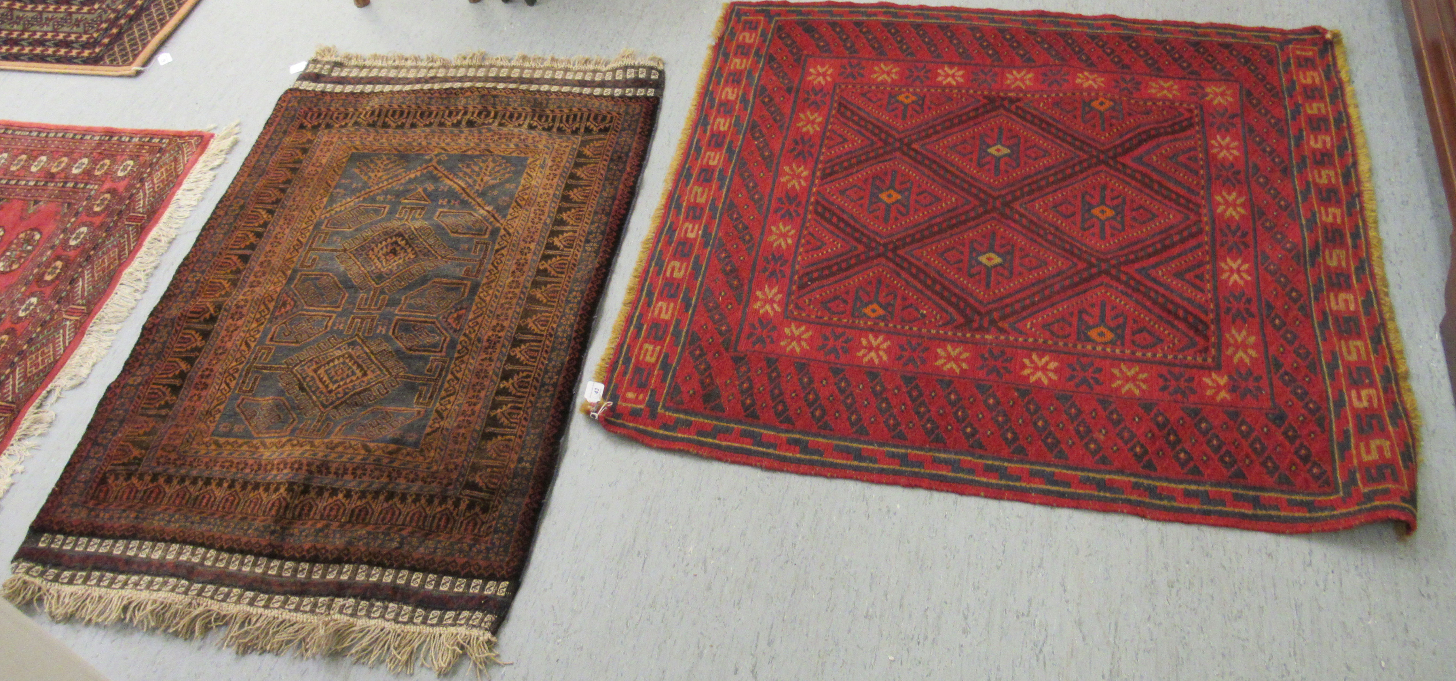 Two woollen Persian rugs, decorated in stylised designs,