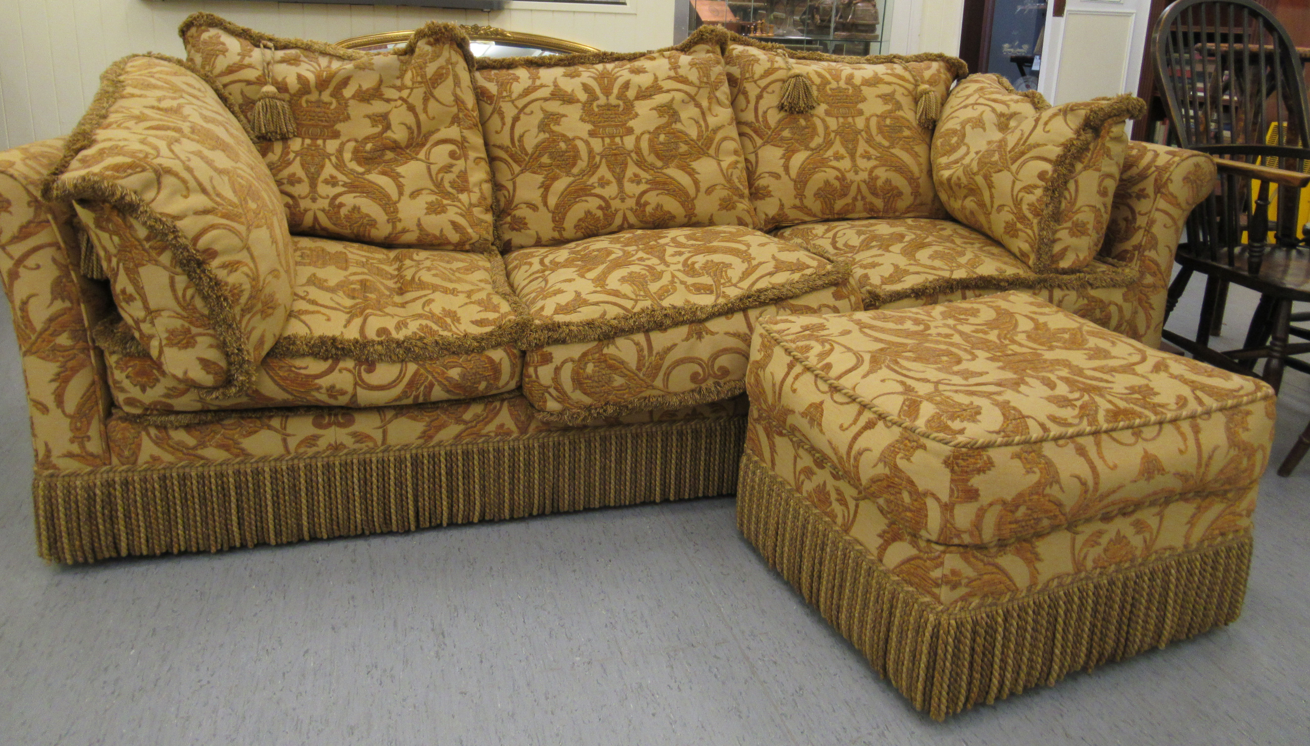 A modern three person settee with a low back and level, scrolled arms,