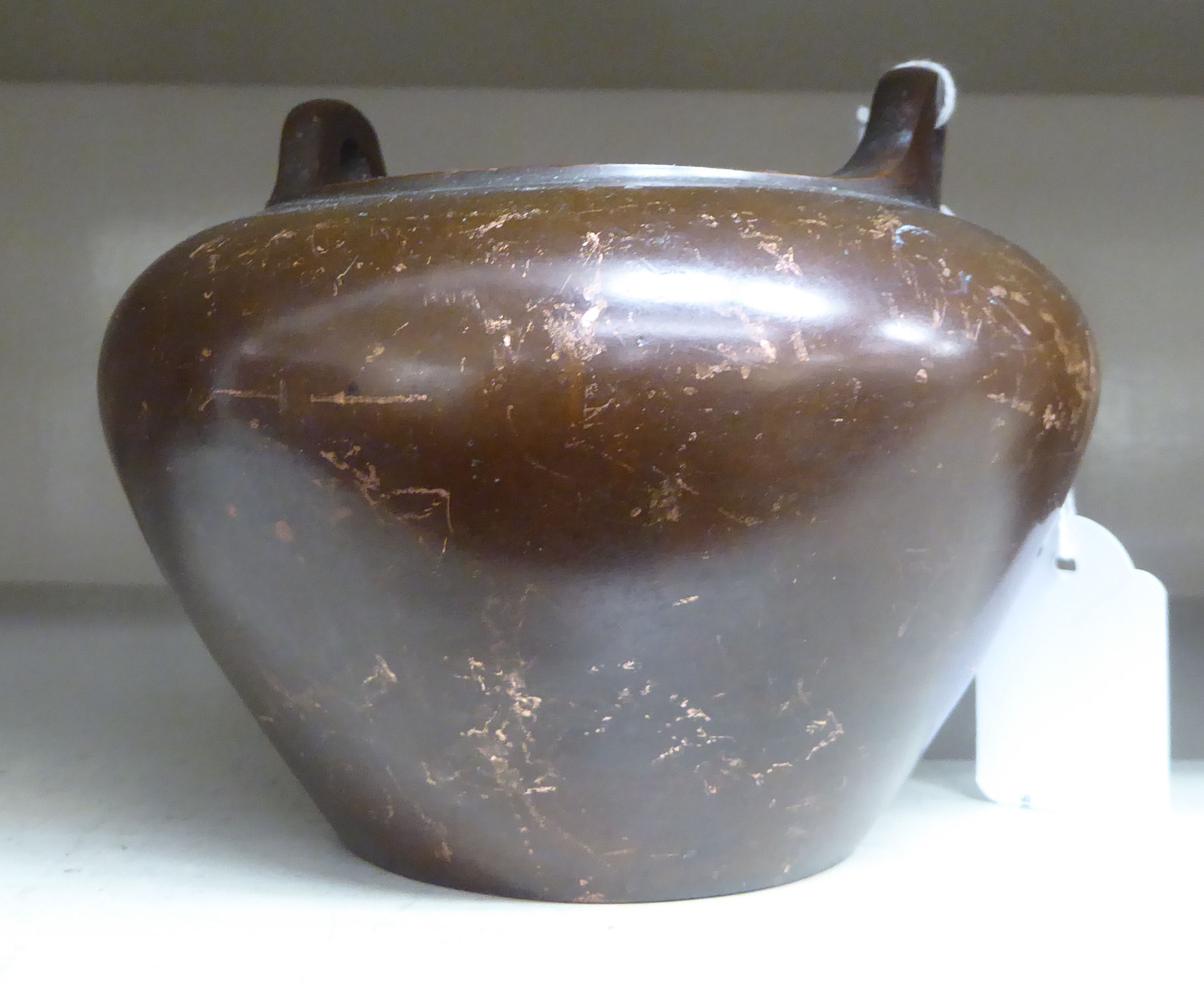 An Oriental cast and patinated bronze censer, the tapered, bulbous bowl with opposing,