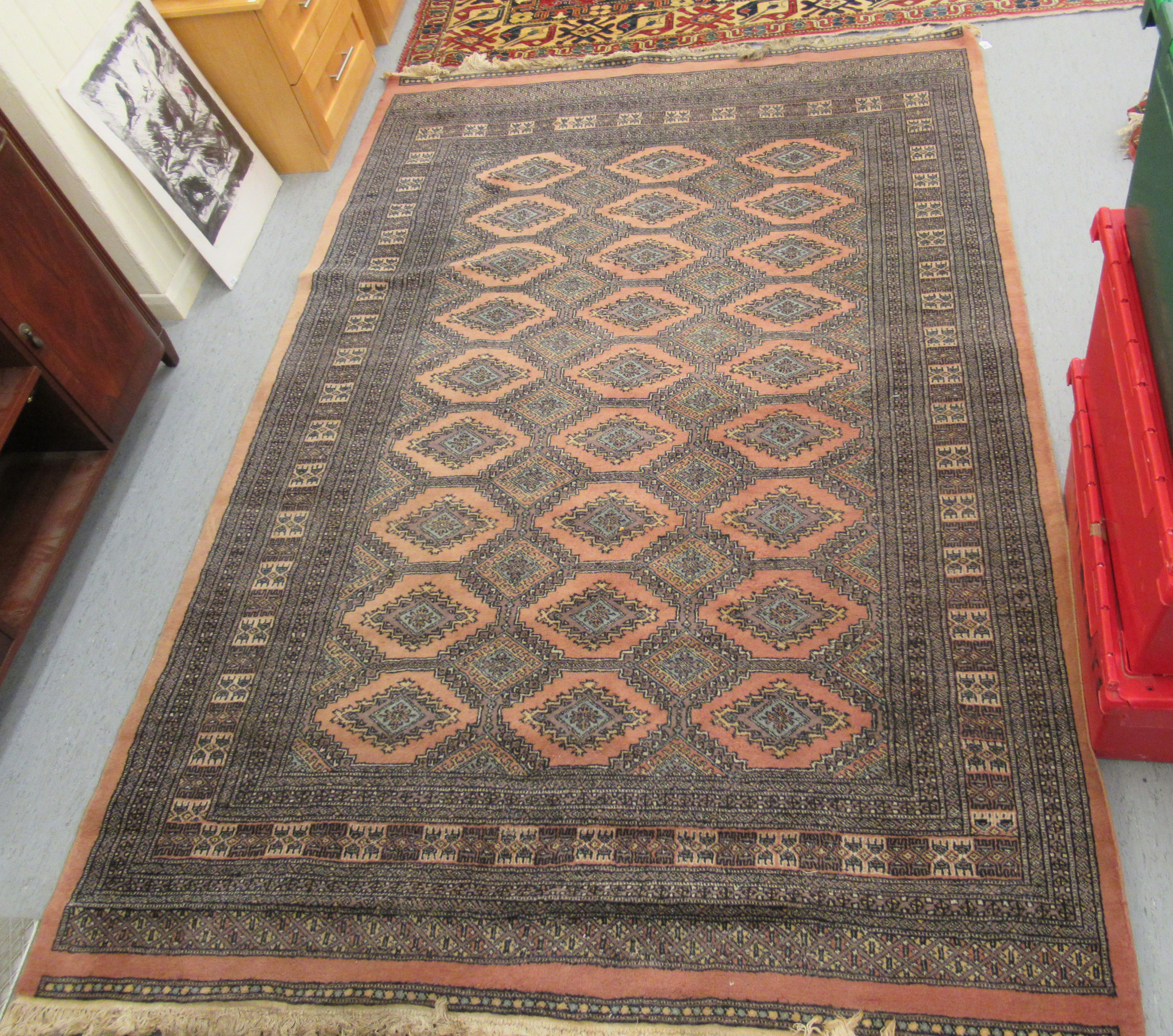 A Persian rug, decorated with repeating stylised diamond formations,