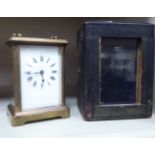 A 1930s lacquered brass cased carriage timepiece with bevelled glass panels and a folding top