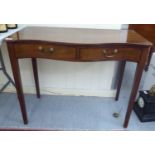 An early 19thC mahogany serpentine front side table with two drawers, raised on square,