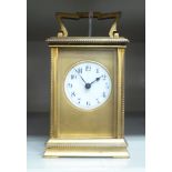An early 20thC gilt metal cased carriage timepiece with bevelled glass panels and a folding top