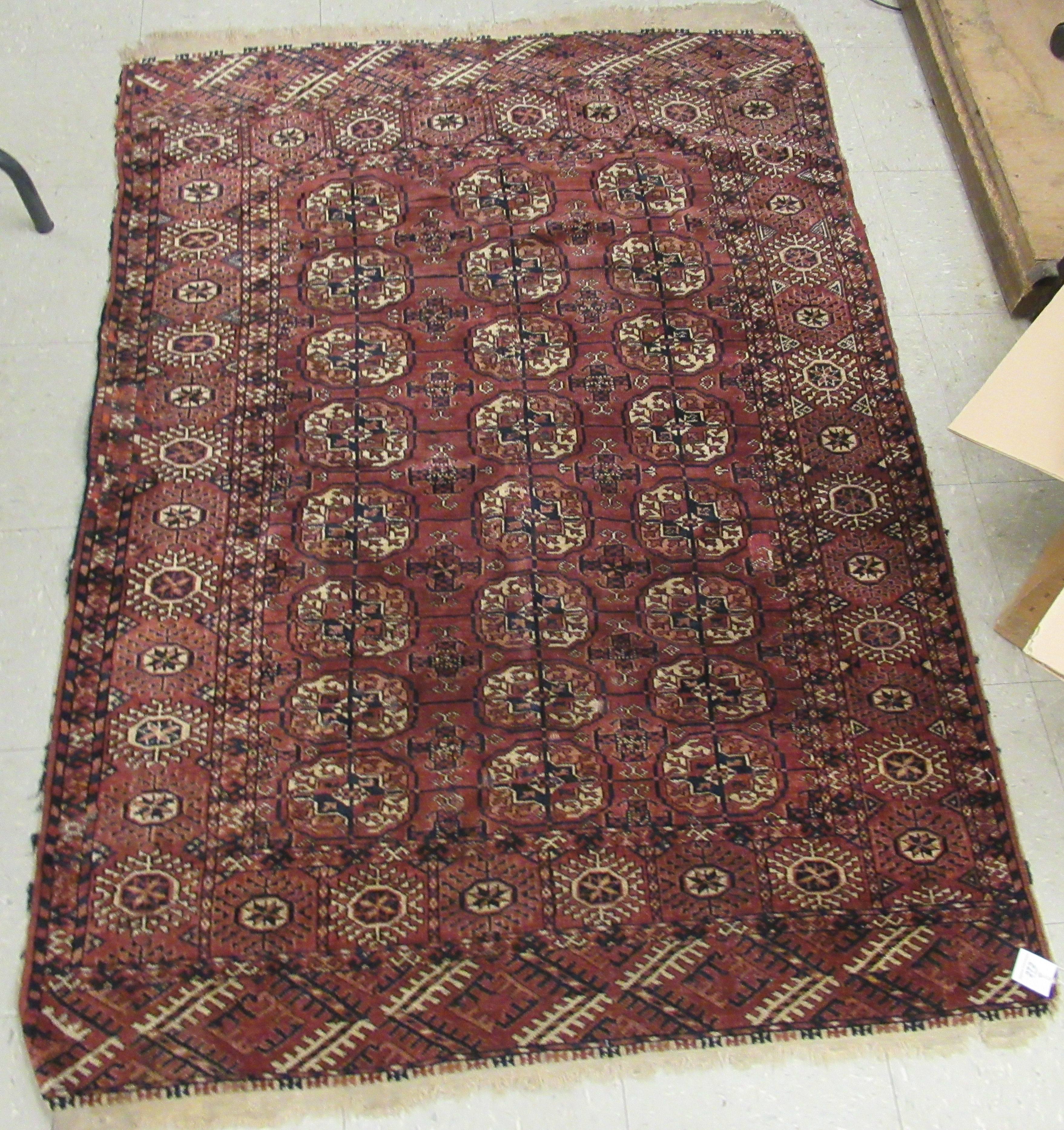 A Bokhara rug, decorated with three columns of seven guls, bordered by stylised designs,
