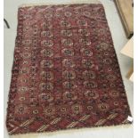 A Bokhara rug, decorated with three columns of seven guls, bordered by stylised designs,