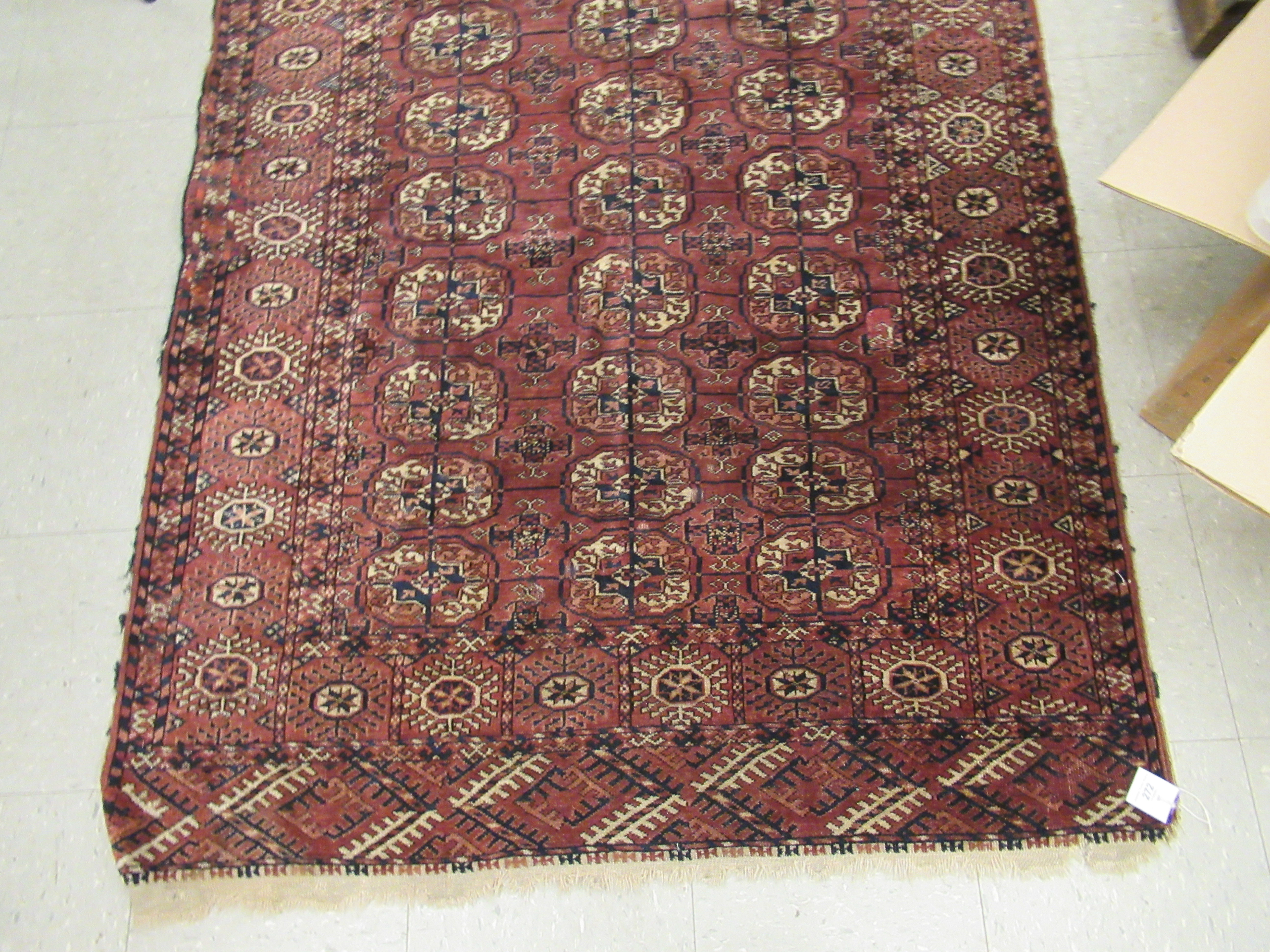 A Bokhara rug, decorated with three columns of seven guls, bordered by stylised designs, - Image 2 of 3