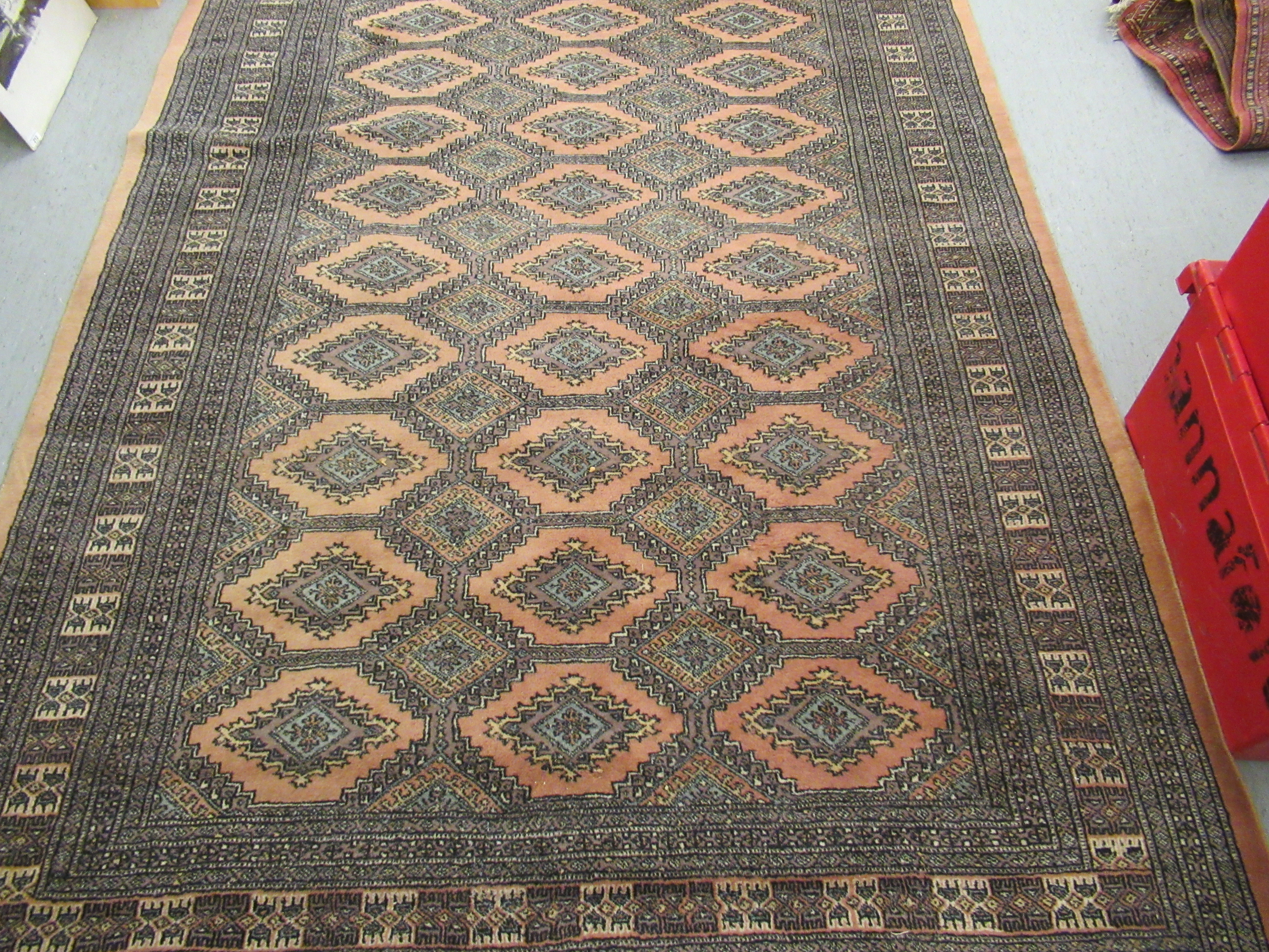 A Persian rug, decorated with repeating stylised diamond formations, - Image 2 of 4