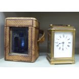 A 1930s lacquered brass cased carriage clock with bevelled glass panels and a folding top handle;