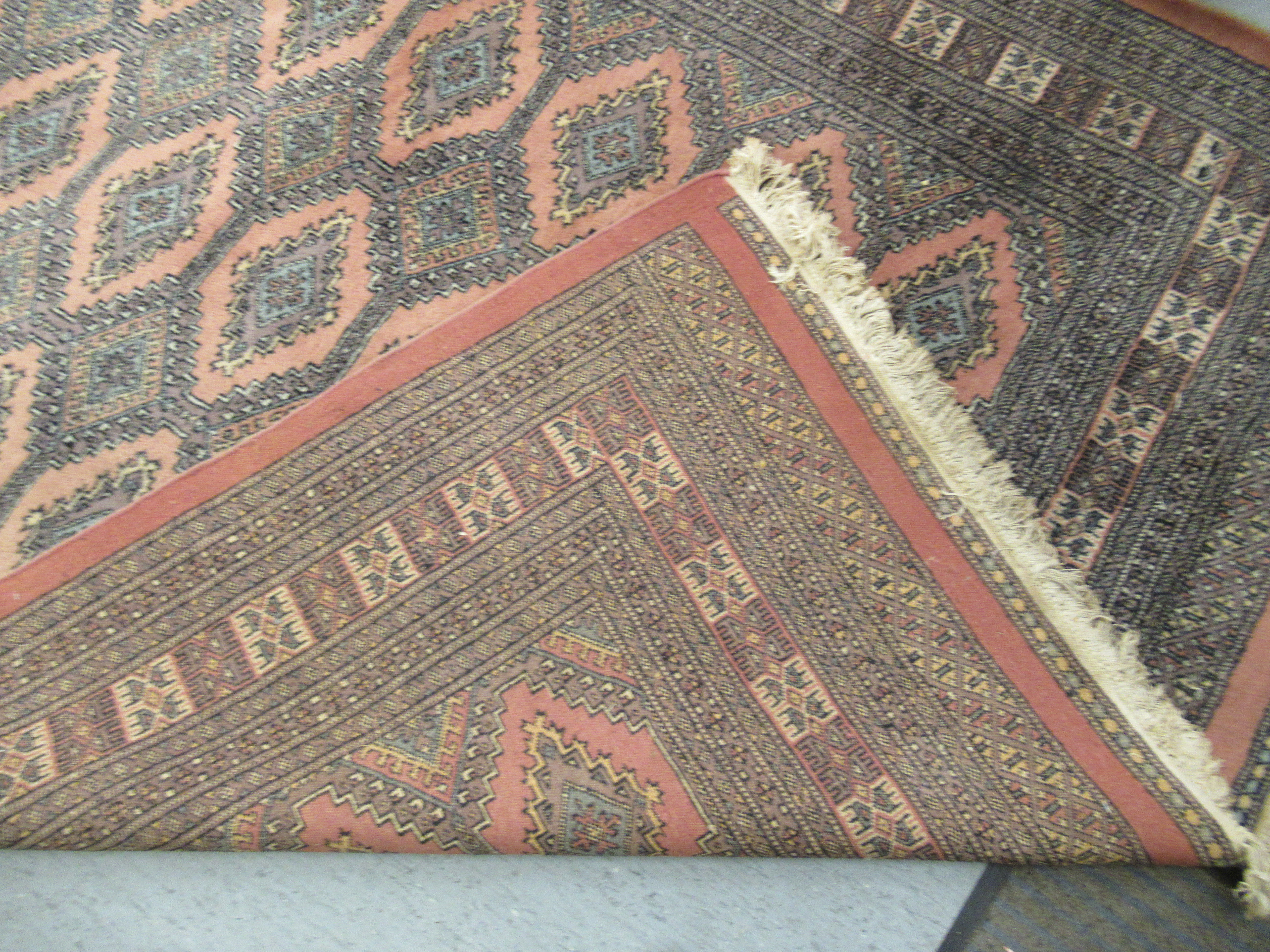 A Persian rug, decorated with repeating stylised diamond formations, - Image 4 of 4