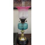 A late Victorian brass and glass oil lamp with a turquoise coloured reservoir,