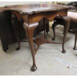 An Edwardian mahogany centre table, the serpentine outlined top raised on slender, cabriole legs,