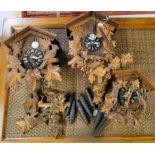 Three similar 20thC German carved limewood cuckoo clocks with various weights BSR