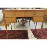 A mid 20thC light oak kneehole dressing table with two short/two long drawers, raised on tapered,