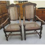 A pair of late 19thC baronial style, oak framed, high back chairs with carved crests, side pillars,