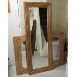 A modern dressing mirror, set in a moulded waxed pine frame 53'' x 20''; and another,