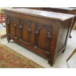 A 1930s oak chest, the hinged lid over a tri-panelled front,