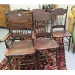 A set of five early 20thC American oak framed dining chairs with foliate carved tablet crests and