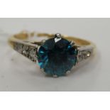 An 18ct gold ring, set with a central blue stone,