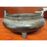 An Oriental cast bronze censer, the shallow, bulbous bowl with opposing handles,