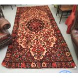 A Persian rug, profusely decorated with floral designs,