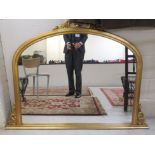 A modern round arched overmantel mirror,