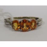 A 9ct white gold ring, set with three graduated oval, yellow sapphires approx.1.