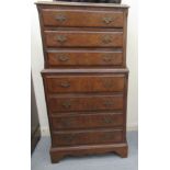 A mid 20thC walnut veneered tallboy, comprising seven long drawers with brass handles,