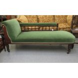 An Edwardian mahogany framed chaise longue with a spindled back, upholstered in bottle green dralon,