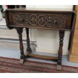 A 20thC reproduction of a Jacobean inspired oak hall table with opposing fall flaps,
