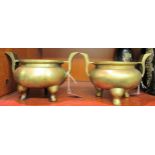 A pair of Oriental cast and patinated bronze censers, the bulbous bowls with opposing,