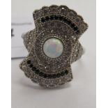 An Art Deco style silver coloured metal ring, set with an opal panel,