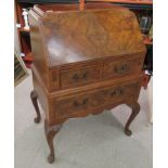 A mid 20thC walnut bureau with a fall front, over two short/one long drawer,